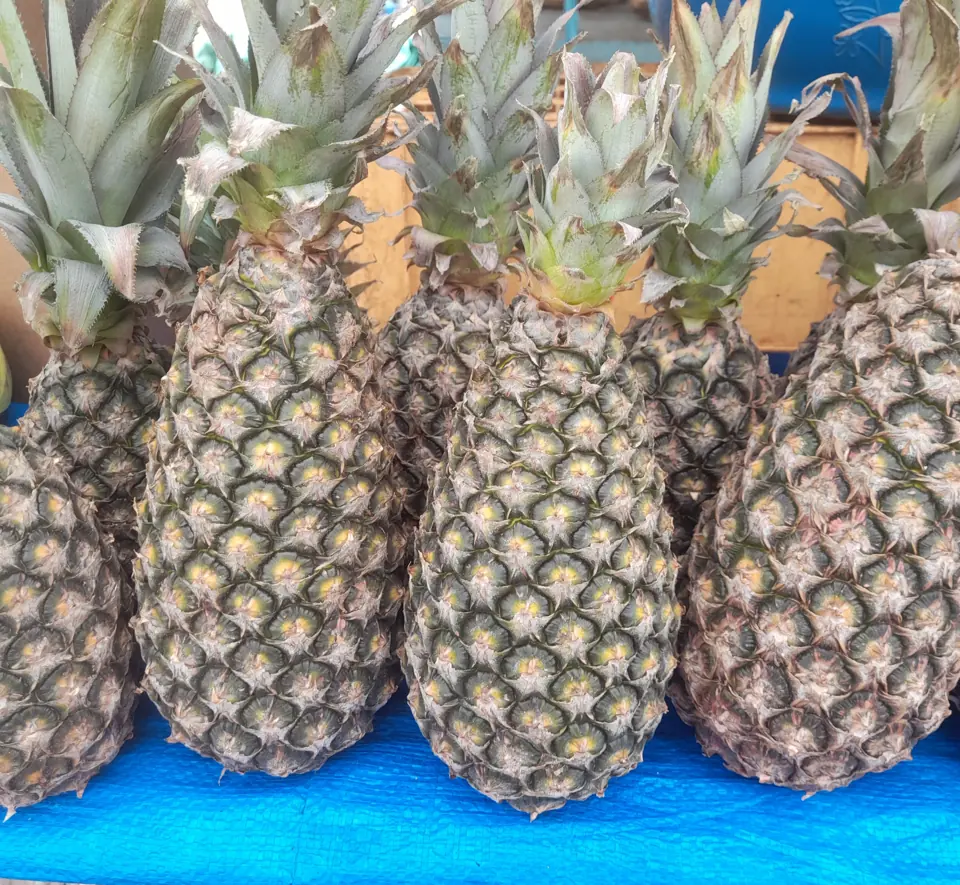 Whole pineapples stacked at a market
